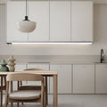 Grey wireless LED motion sensor light glowing under a kitchen cupboard — Aura Sensor Light — Touched Home
