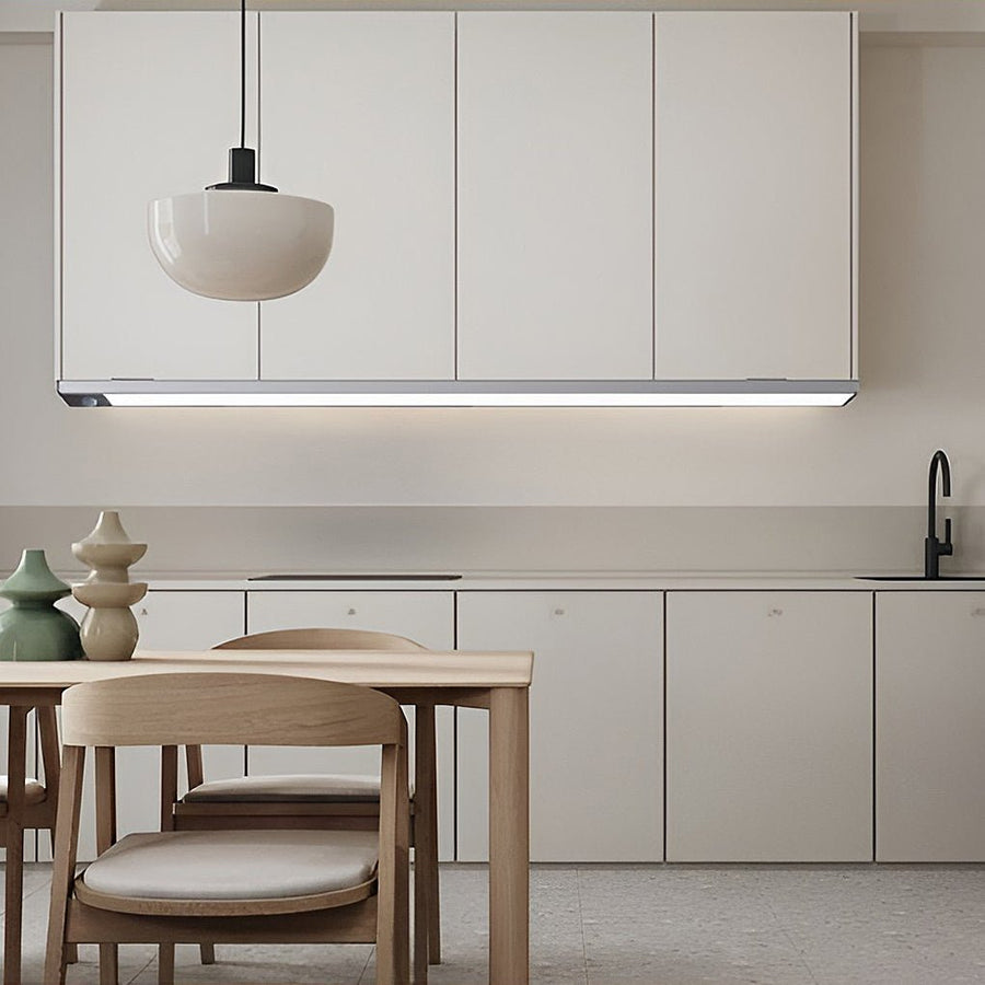 Grey wireless LED motion sensor light glowing under a kitchen cupboard — Aura Sensor Light — Touched Home